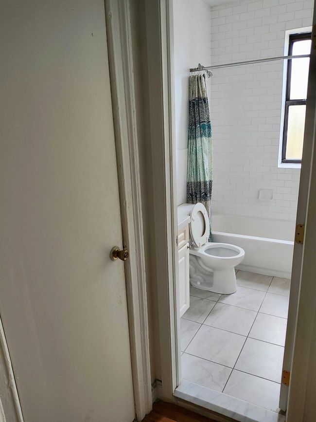 Bathroom featuring tub / shower combination, tile patterned flooring, and toilet | Image 12