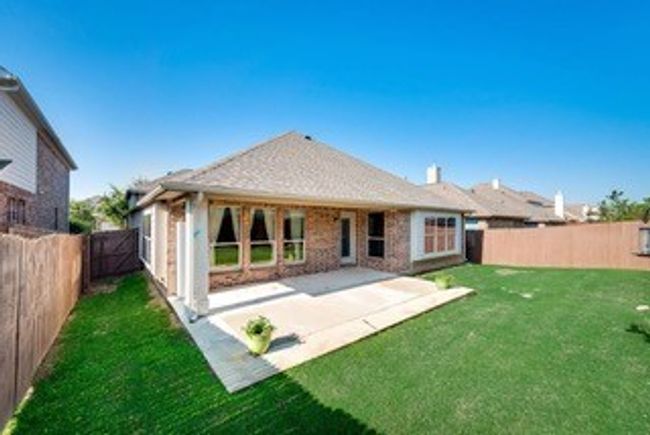 Rear view of house featuring a fenced backyard and a patio area | Image 15