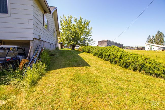 View of green lawn featuring a garage | Image 6