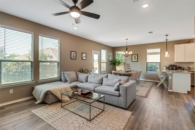 Living area with healthy amount of natural light, a ceiling fan, wood finished floors, and recessed lighting | Image 6