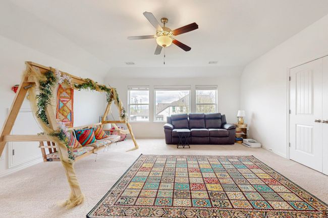 Living area featuring carpet flooring, visible vents, and a ceiling fan | Image 25