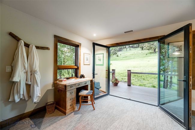 Upper level guest bedroom with French doors that bring the outside in. | Image 43