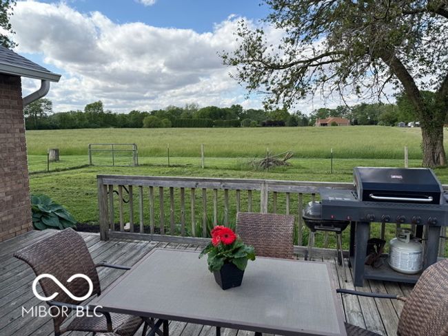 wooden deck with a view of countryside, a yard, area for grilling, and outdoor dining area | Image 6