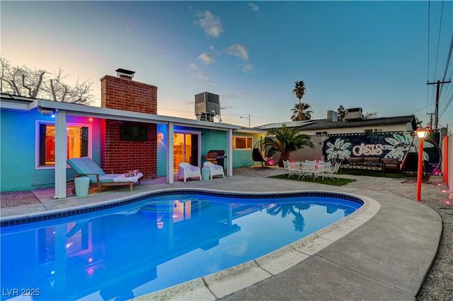 Rear view of house featuring a chimney, central AC unit, an outdoor pool, and a patio | Image 39