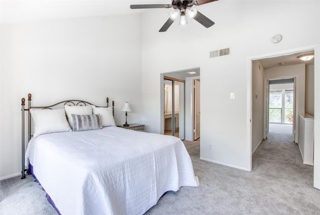 Bedroom featuring light carpet, high vaulted ceiling, a ceiling fan, and ensuite bath | Image 20