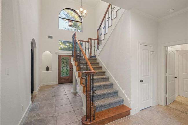 Inviting foyer featuring a high ceiling with a large arched window. | Image 10