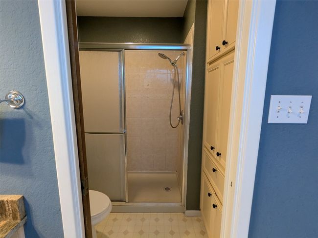 Full bath with a shower stall, tile patterned floors, and a textured wall | Image 25