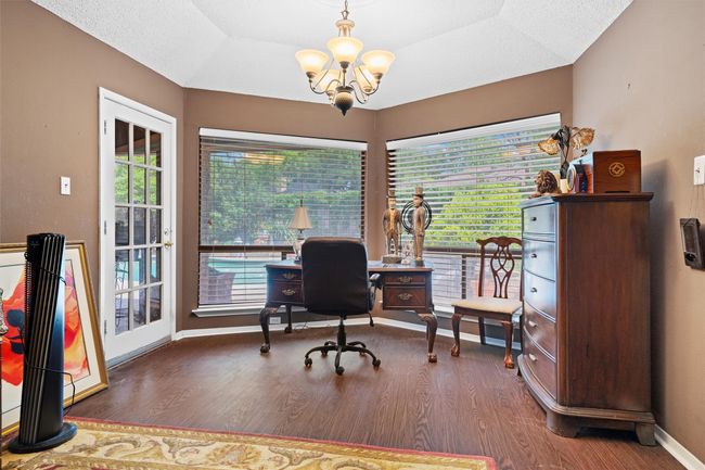 Office featuring baseboards, wood finished floors, and a chandelier | Image 13