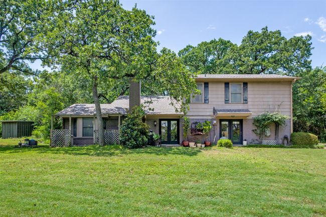View of front of property featuring french doors, a front yard, a chimney, and brick siding | Image 4