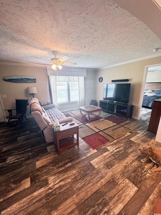 Living room with ornamental molding, wood finished floors, a textured ceiling, and ceiling fan | Image 10