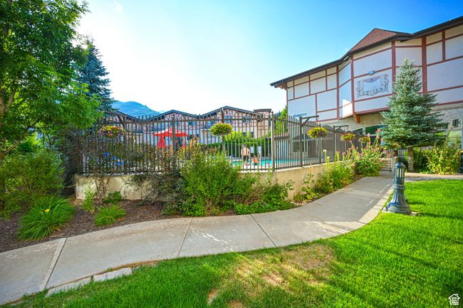 View of property's community with a pool, a yard, and fence | Image 4