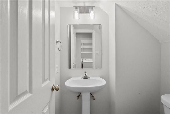 First floor half-bathroom with a pedestal sink and updated lighting. | Image 34