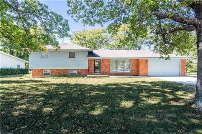 Tri-level home featuring a front lawn and a garage | Image 1