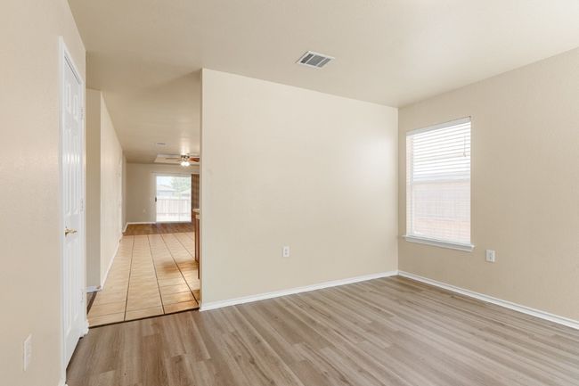 Empty room with light wood-type flooring and ceiling fan | Image 7
