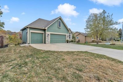 View of front facade with a front lawn and a garage | Image 1