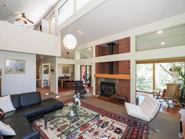 Carpeted living area with healthy amount of natural light, a towering ceiling, ceiling fan, and recessed lighting | Image 11