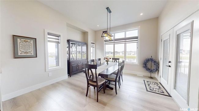 Dining space featuring light wood-style floors, recessed lighting, and a chandelier | Image 9