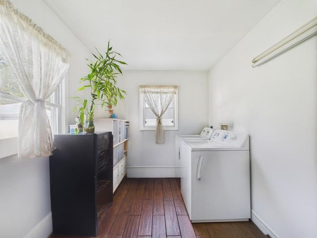 Laundry room with washer and dryer and dark wood-style floors | Image 23