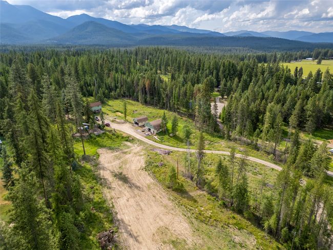 Bird's eye view of a heavily wooded area and a mountainous background | Image 29