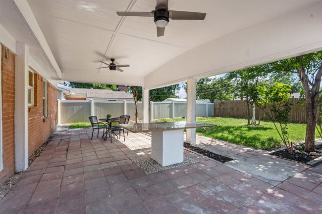 Fenced backyard featuring ceiling fan, a patio, and outdoor dining space | Image 26
