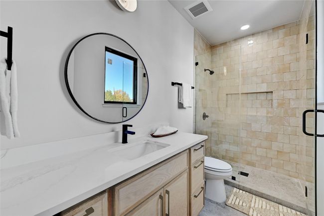 Bathroom featuring toilet, vanity, an enclosed shower, and tile patterned flooring | Image 13