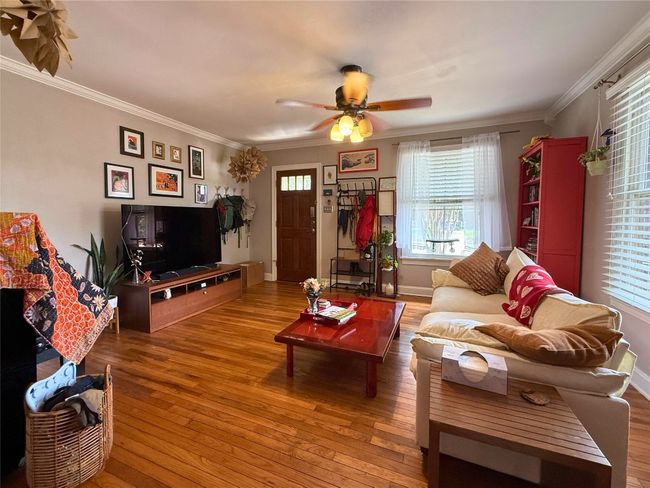 Living area with wood flooring, ornamental molding, and a ceiling fan | Image 4