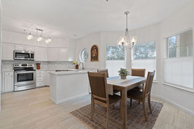 Dining room into the Kitchen area, with beautiful floors and ambient natural lighting. | Image 7