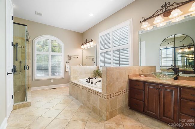 Primary bath with tile flooring, dual vanities, huge walk-in shower, and whirlpool tub | Image 19