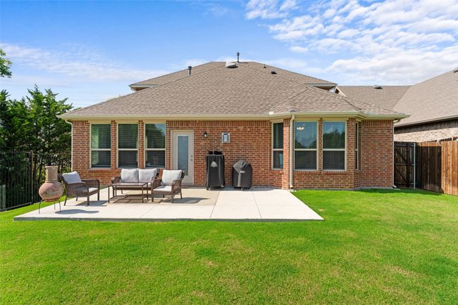 Back of property featuring a shingled roof, a fenced backyard, a patio area, outdoor lounge area, and brick siding | Image 32