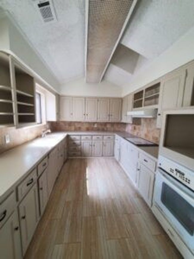 Kitchen with open shelves, oven, tasteful backsplash, and dark wood-style flooring | Image 16