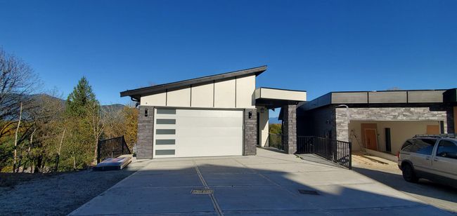 View of front of property with board and batten siding, stone siding, and concrete driveway | Image 31