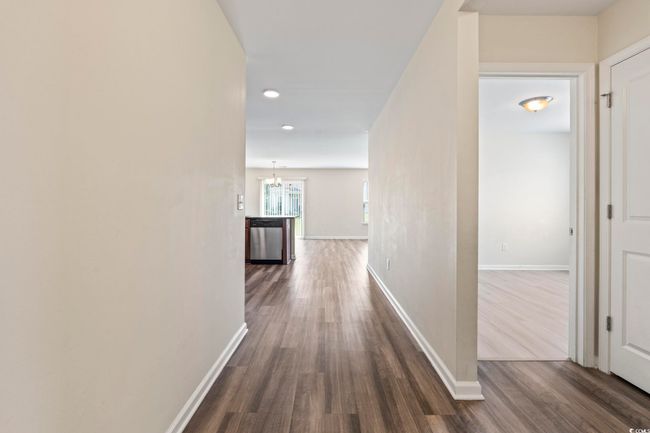 Hall featuring dark wood-style flooring, recessed lighting, and a chandelier | Image 8