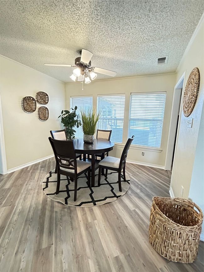 Dining room featuring visible vents, baseboards, a textured ceiling, and wood finished floors | Image 14