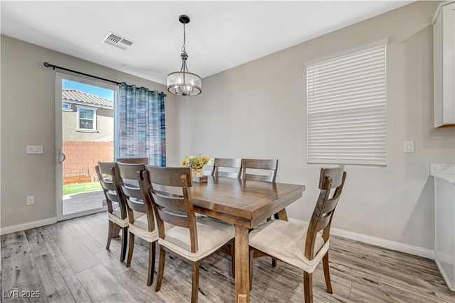 Dining area featuring light wood-type flooring, a chandelier, and baseboards | Image 15