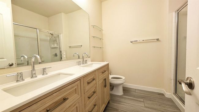 Full bathroom featuring a sink, toilet, a stall shower, and baseboards | Image 7