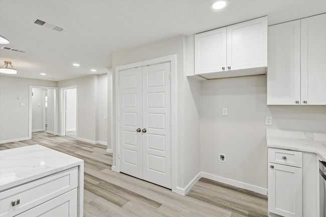 Kitchen with recessed lighting, visible vents, and white cabinets | Image 18