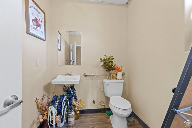 Bathroom featuring baseboards, wood finished floors, toilet, and a sink | Image 13