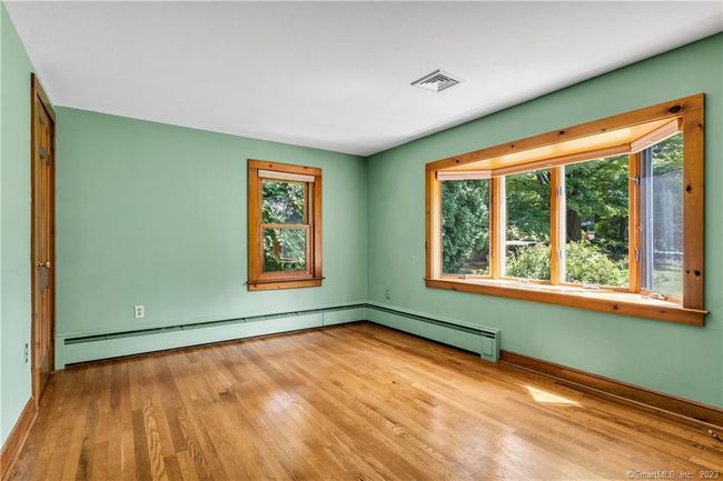 The Primary Bedroom has a pretty bow window and hardwood floors. | Image 15
