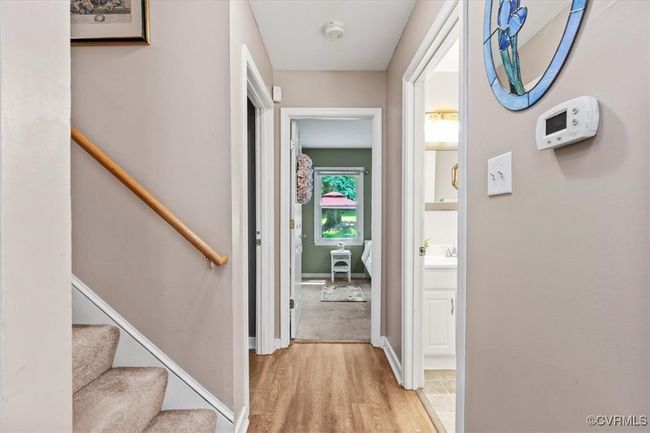 Hall with light wood-style flooring, baseboards, and a sink | Image 21