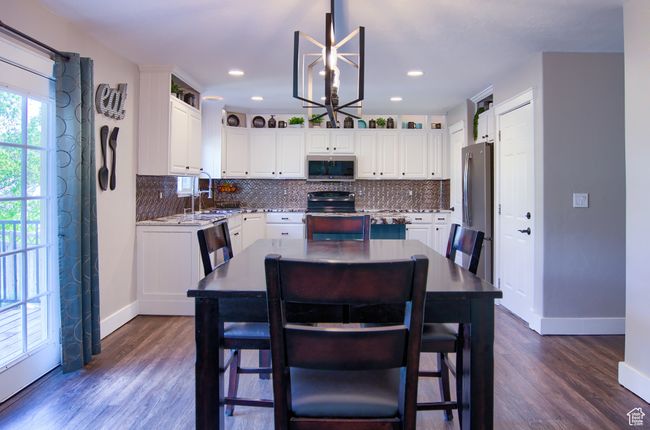 Kitchen featuring decorative backsplash, baseboards, white cabinetry, and stainless steel appliances | Image 40