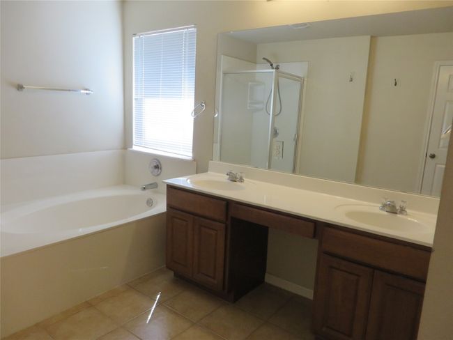 Bathroom with double vanity, a bath, tile patterned flooring, and a shower stall | Image 11