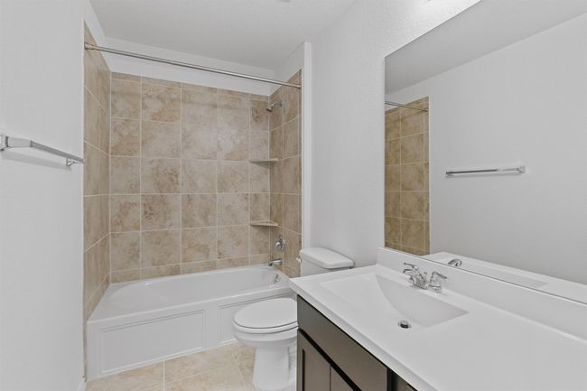 Bathroom featuring tub / shower combination, vanity, toilet, and tile patterned floors | Image 30