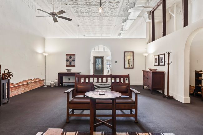 Carpeted dining space featuring a towering ceiling, baseboards, arched walkways, and a ceiling fan | Image 20