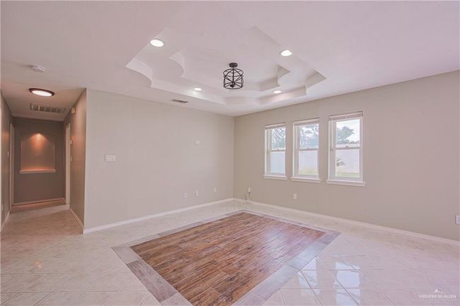 Empty room featuring visible vents, light tile patterned floors, and a raised ceiling | Image 8