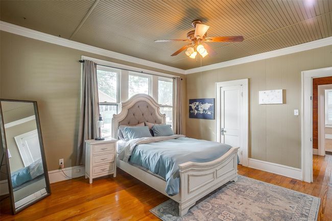 Bedroom featuring light wood finished floors, crown molding, and ceiling fan | Image 38