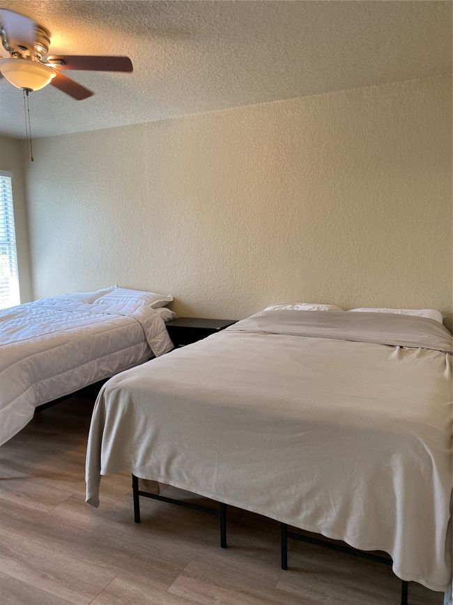 Bedroom with wood finished floors, a textured wall, and ceiling fan | Image 10