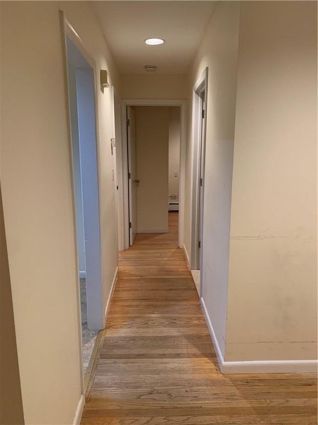 1st Fl Hall with light hardwood / wood-style floors and a baseboard radiator | Image 20