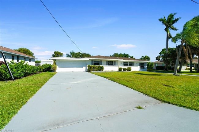 Ranch-style house featuring stucco siding, concrete driveway, a garage, and a front yard | Image 23