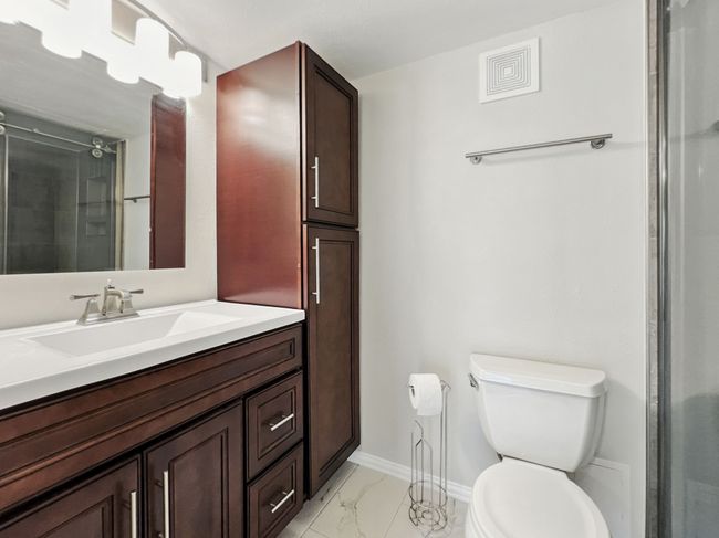 Bathroom featuring vanity, a shower stall, and light marble finish flooring | Image 12