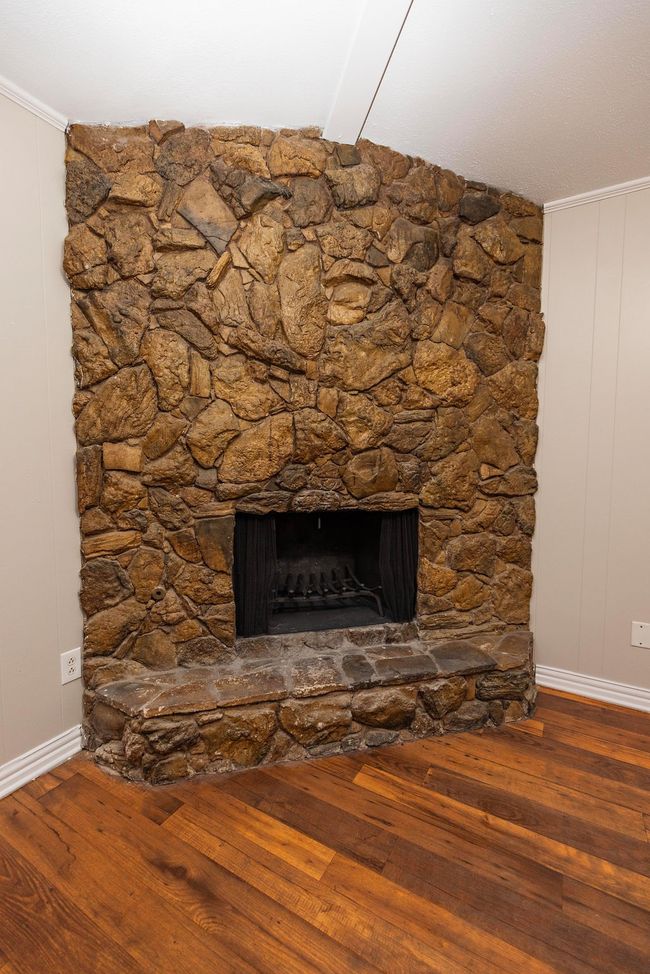 Detailed view of wood finished floors, baseboards, a fireplace, beamed ceiling, and ornamental molding | Image 21